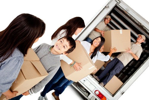 Removal company unloading boxes and furniture at a new property