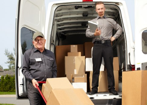 Professional removals crew working safely with protective gear